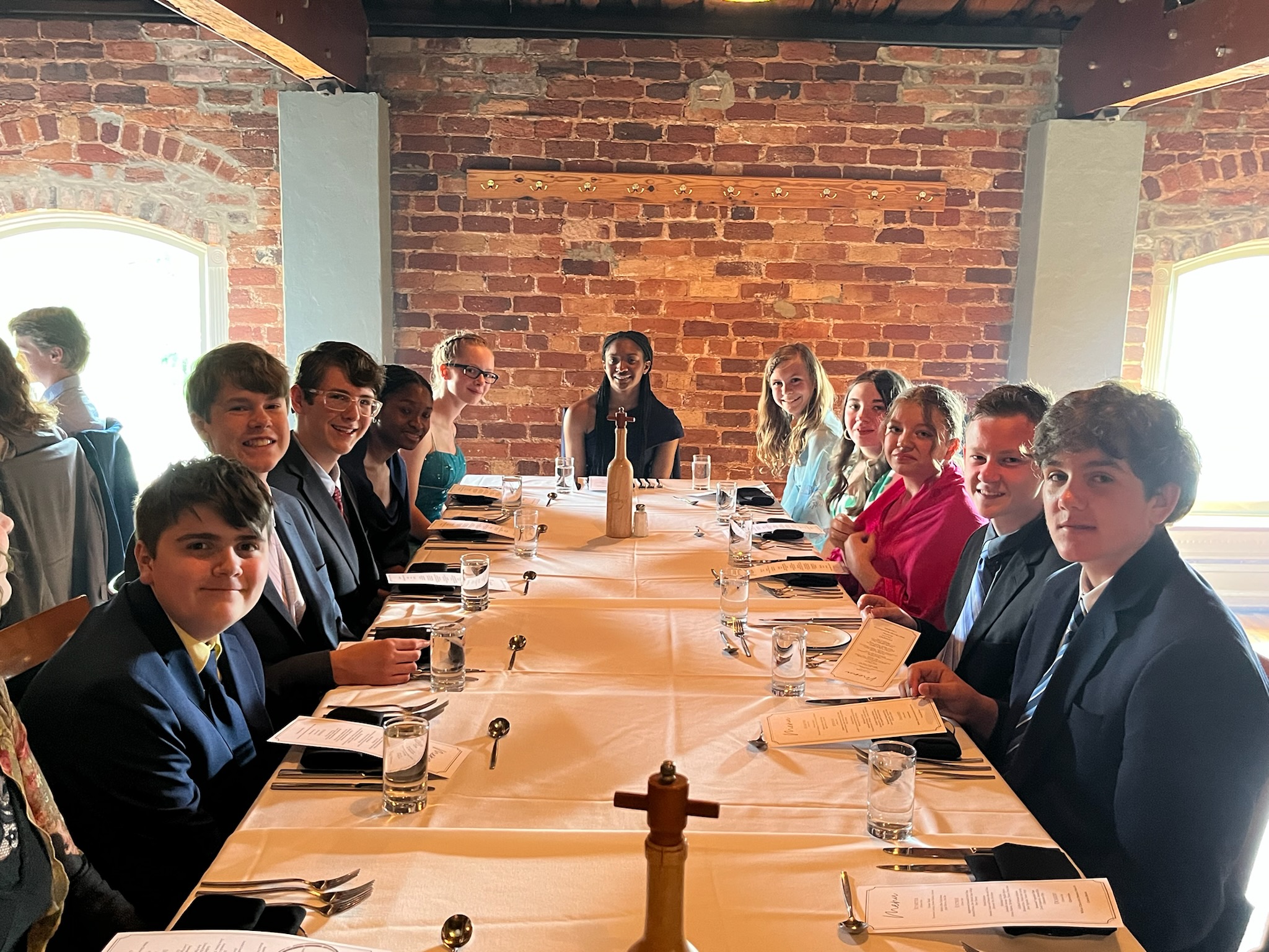 Students at a formal table for Classical Conversations Protocol
