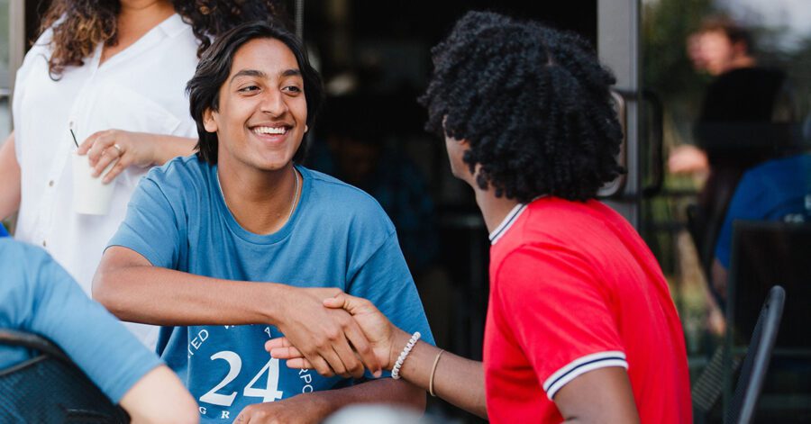 Two homeschool high school students shaking hands.