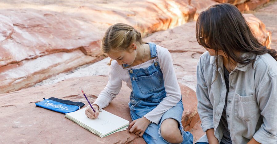Mother and daughter homeschooling outside.