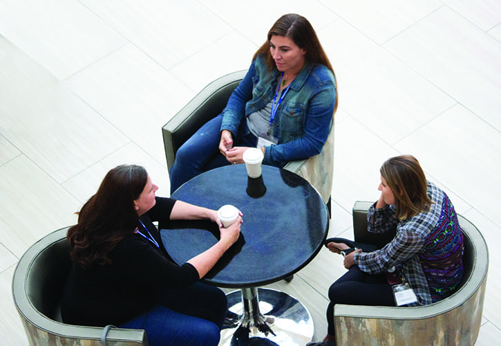 three homeschool moms talking around a table 