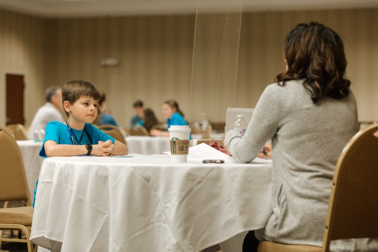 a student recites memory work in front of judges at National Memory Master