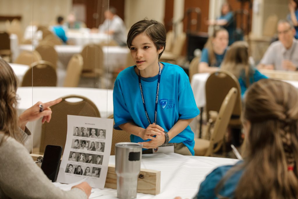 a student recites memory work in front of judges at National Memory Master