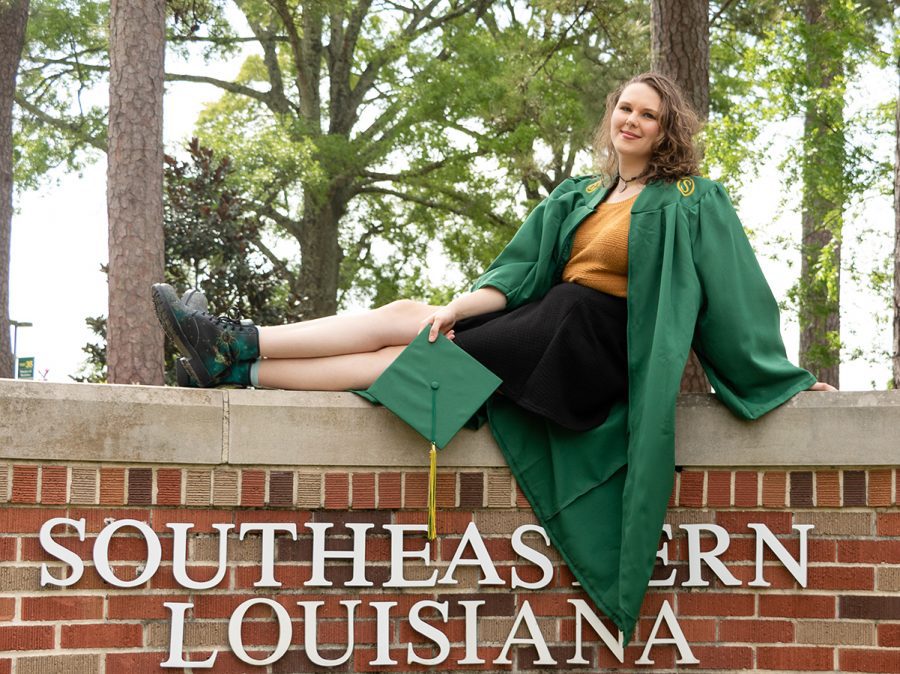 A homeschool student posing in front of a sign for Southeastern Louisiana University