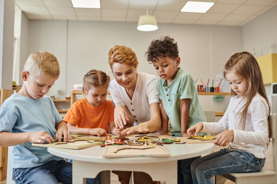 A smiling homeschool teacher or parent teaches homeschoolers using the Montessori method.
