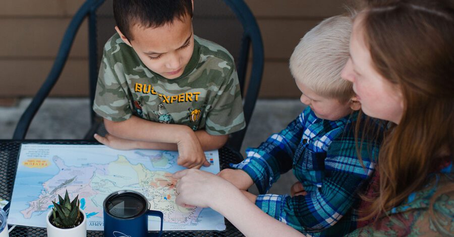 A homeschool family learning from a map in the Foundations program.