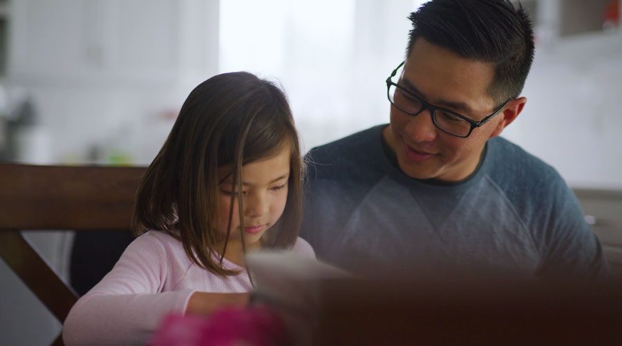 A father and daughter working through math curriculum together.