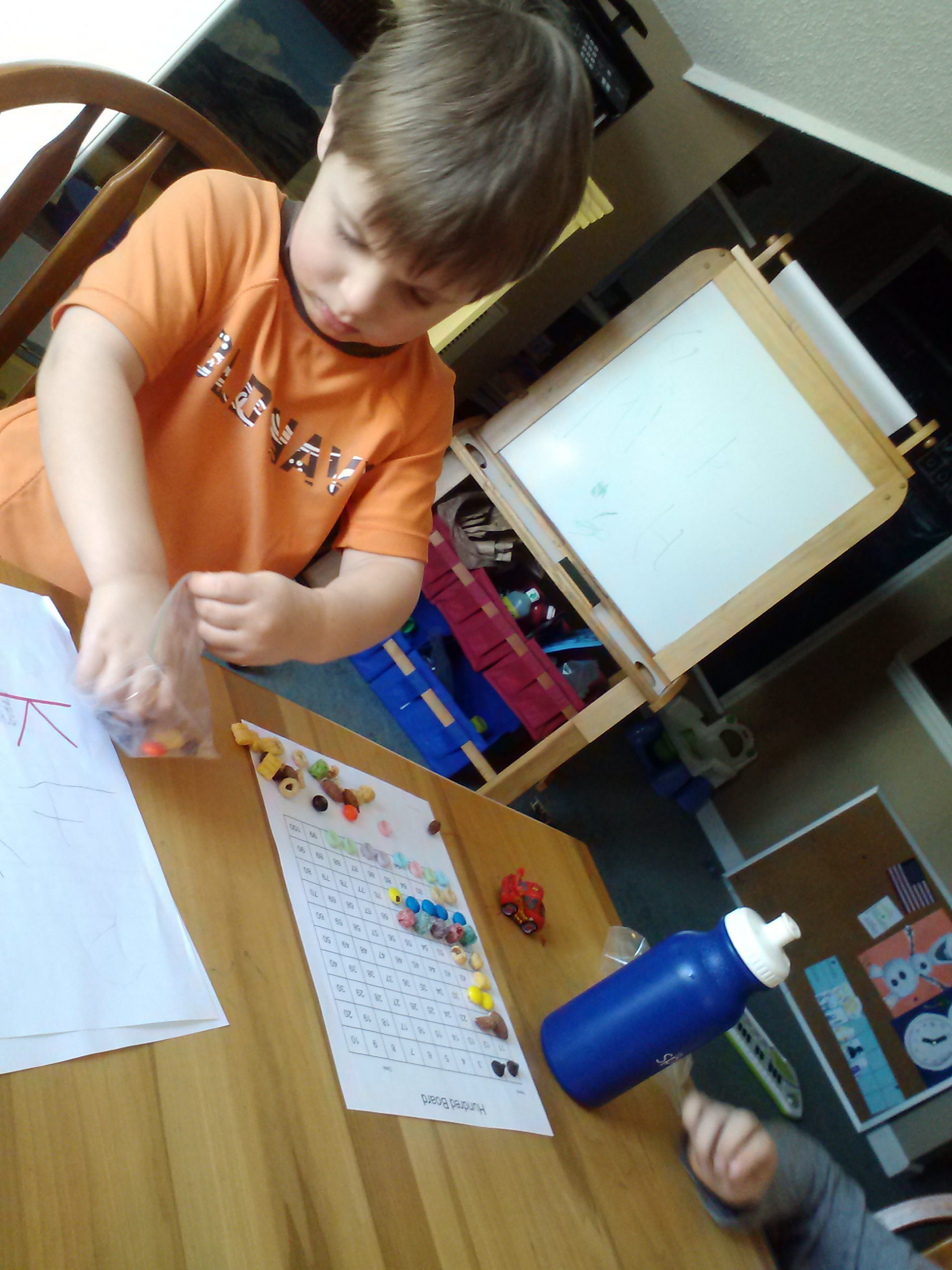 Young homeschool boy doing math at a table.