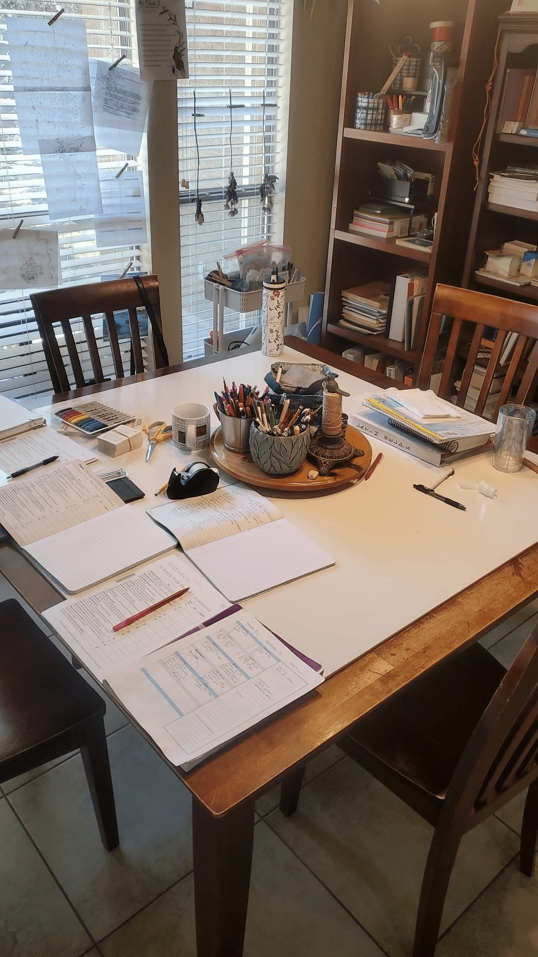 Homeschool work laid out on the dining room table.