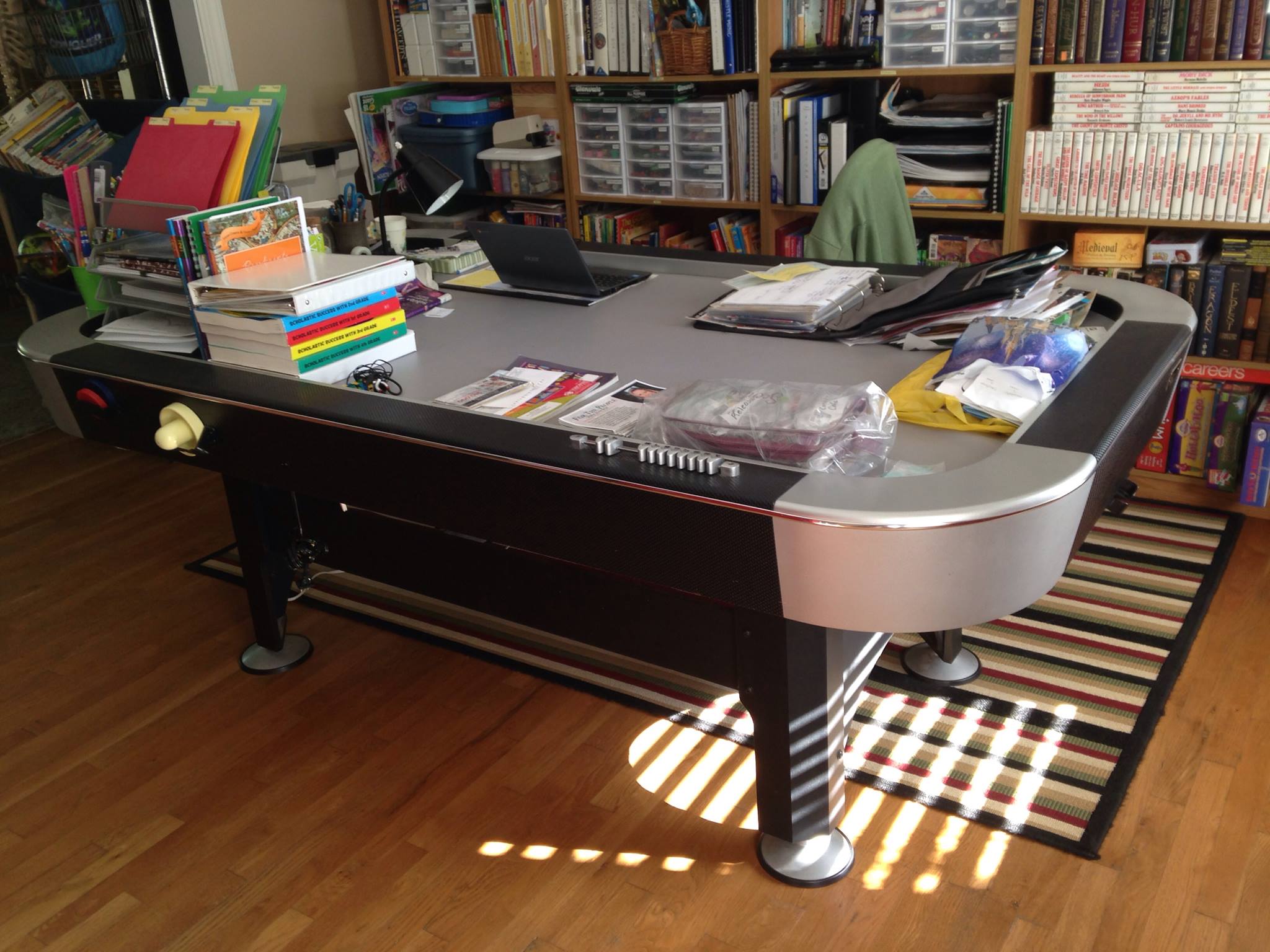 A pool table being used as a homeschool desk.