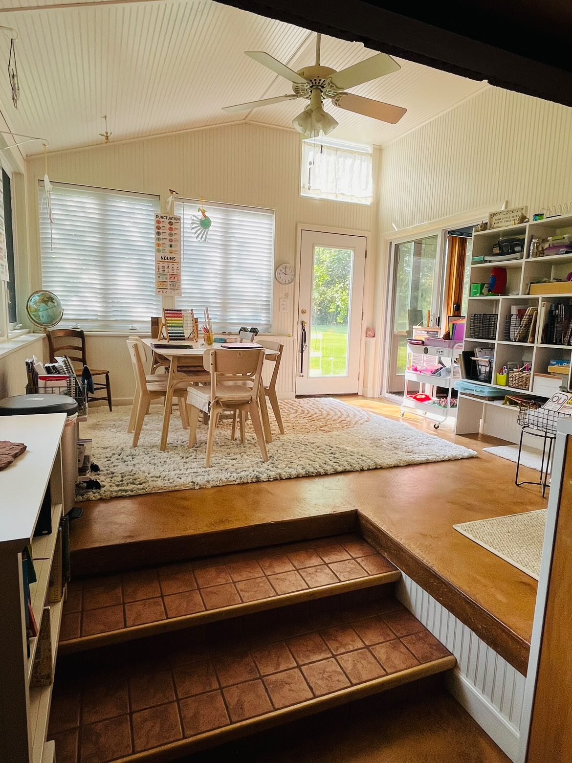 Homeschool room with bookcases and large windows.