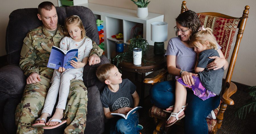 Homeschool family sitting together, reading a book.