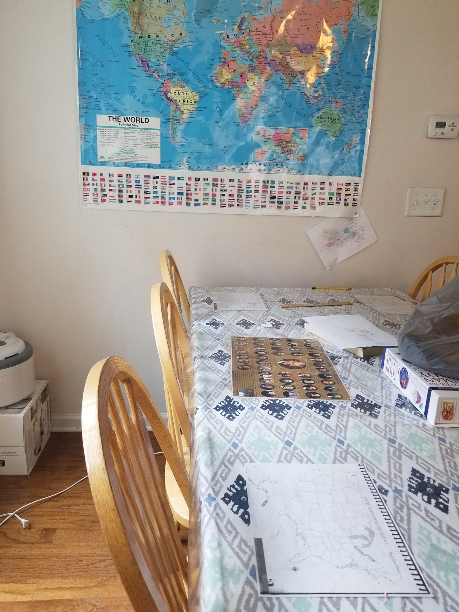 A world map on the wall and homeschool work on the kitchen table.