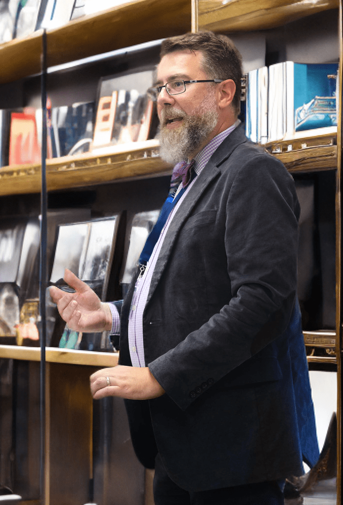 Timothy Knotts, homeschool dad and author of Reasoning Together Philosophy, teaching at a podium in a bookstore.