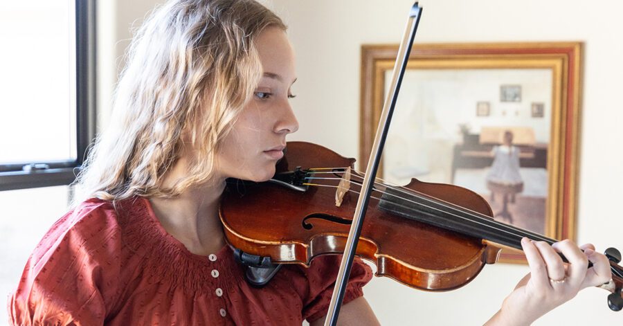 Homeschool student practices the violin.