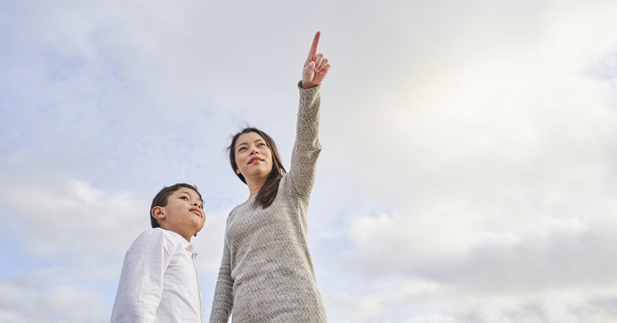 Homeschool student looks to where his mother is pointing to the sky