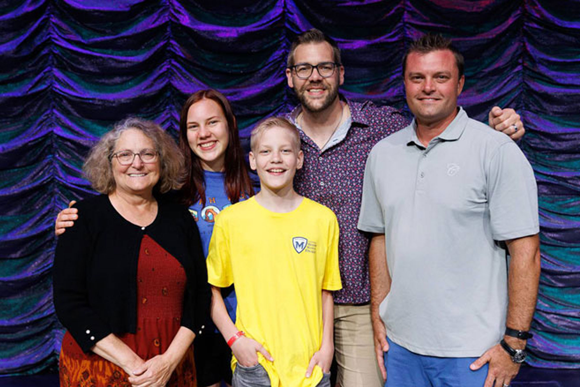 The 2026 National Memory Master winner with family on stage with Robert and Leigh Bortins