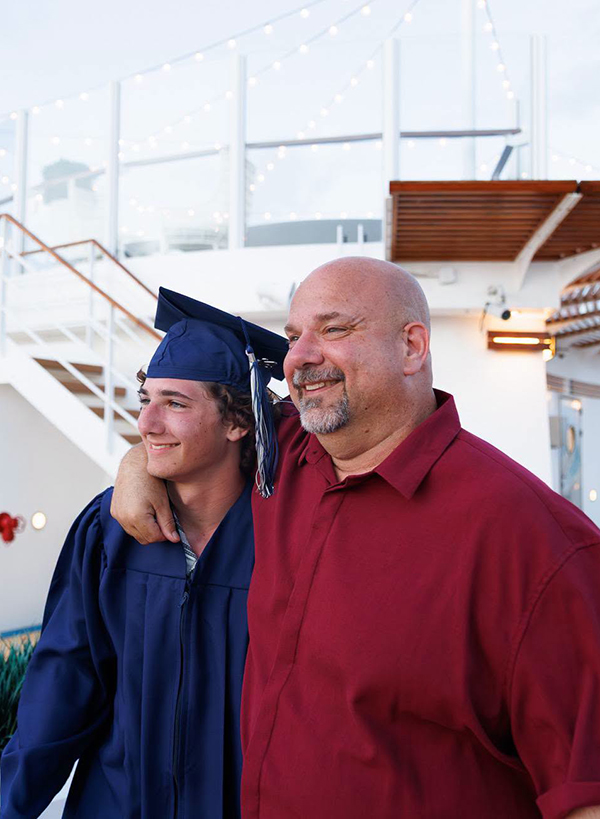 National Commencement 2026 - Dad and son in cap and gown after Commencement